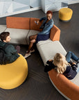 Three people sitting on modern, colorful furniture in a stylish interior setting. Kansas City Office Design.