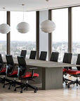 Modern conference room with a large table and chairs near large windows with a cityscape view. Kansas City Office Design.