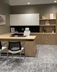 Modern office setup with a L-shaped desk, chairs, and shelves. Kansas City Office Design.