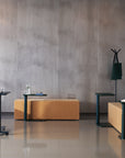 Modern office furniture including the Humanscale Float micro tables on glides and casters at different heights, chairs, and benches against a concrete wall. Kansas City Office Design.