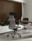 Modern office setup with ergonomic chair, desk, and computer setup. Kansas City Office Design