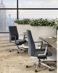 Modern office chairs in a room with large windows and cityscape view. Kansas City Office Design