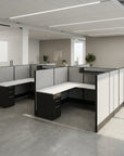 Modern office cubicle setup with white and black furniture in a bright room. Kansas City Office Design
