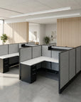 Modern office cubicle setup with gray partitions and white surfaces in a bright room. Kansas City Office Design