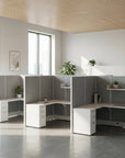 Modern office setup with white desks and gray partitions in a bright room. Kansas City Office Design