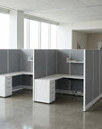 Modern office setup with L-shaped desk and gray partition walls. Kansas City Office Design