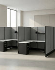 Modern office cubicle setup with gray partitions and white desks in a bright room. Kansas City Office Design