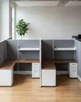 Modern office setup with L-shaped desk and partitioned workstations. Kansas City Office Design