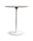 Humanscale Float Gather 36" round Table in white base with walnut veneer top in standing position. Kansas City Office Design.