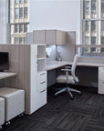 Modern office cubicle with desk, chair, and cabinets in a cityscape setting. Kansas City Office Design