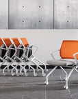 Orange office chairs with white frames arranged against a concrete wall. Kansas City Office Design.