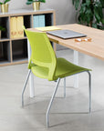 Green SitOnIt Lumin Stack chair in front of a wooden desk with a laptop and glasses in an office setting. Kansas City Office Design.