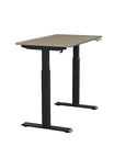 Side view of the SitonIt Switchback Height Adjustable Sit-to-Stand Desk. It has a Black base with a 24"D x 42"W Sandalwood top - Kansas City Office Furniture