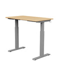 Back view of the SitonIt Switchback Height Adjustable Sit-to-Stand Desk. It has a Silver base with a 24"D x 42"W Maple top - Kansas City Office Furniture