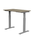 Back view of the SitonIt Switchback Height Adjustable Sit-to-Stand Desk. It has a Silver base with a 24"D x 42"W Sandalwood top - Kansas City Office Furniture