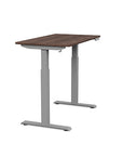 Side view of the SitonIt Switchback Height Adjustable Sit-to-Stand Desk. It has a Silver base with a 24"D x 42"W Walnut top - Kansas City Office Furniture