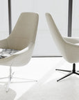 Two modern white Via Astro Lounge chairs with black legs on a white floor with a glass wall background. Kansas City Office Design.