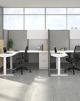 Modern office setup with desks, chairs, and partition walls in a bright room. Kansas City Office Design