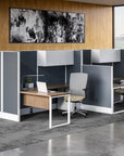 Modern office setup with desks, chairs, and a large abstract painting on the wall. Kansas City Office Design
