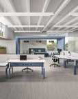 Modern office space with power bench sit to stand desks, chairs, and a large window. Kansas City Office Design.