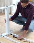 Person assembling the Switchback Height Adjustable Sit-to-Stand Desk - Kansas City Office Furniture