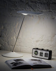Humanscale Horizon 2.0 task light glowing light cascading on the desk, set in the dark. Kansas City Office Furniture.