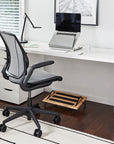 Modern office setup with a black ergonomic chair, white desk, and Humanscale FR300 footrest. Kansas City Office Design.