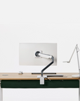 Modern office desk setup with a Humanscale NeatTech cable management installed under the top. It also includes a monitor, keyboard, and lamp on a white background. Kansas City Office Furniture.
