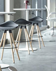 Black stools with wooden legs in a modern interior setting with Humanscale Float Gather tables. Kansas City Office Design.