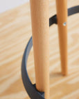 Close-up of a wooden Via Joi Stool with black metal legs on a wooden floor. Kansas City Office Design.