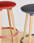 Two Via Joi bar stools with red and gray seats on a wooden floor. Kansas City Office Design.