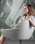 Side view of a women in a Gobi lounge against a wall with tropical leafs. Kansas City Office Design.
