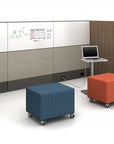 Two colorful ottomans in front of a whiteboard with a laptop on a stand. Kansas City Office Design