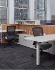 Modern office setup with desks, chairs, and large windows. Kansas City Office Design