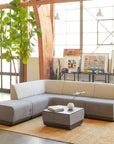 Gray sectional sofa in a modern living room with plants and artwork. Kansas City Office Design.
