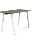 Side view of the SitOnIt Reya Office Desk with Angled Metal Legs. The legs are white with a Sandalwood top. Kansas City Office Furniture