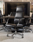 Conference room with black leather chairs and a large screen in the background. Kansas City Office Design