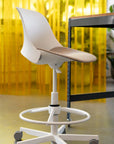 White office chair with a yellow curtain in the background. Kansas City Office Design