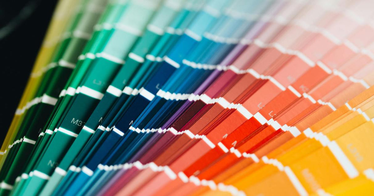 Fanned-out paint color swatch samples in a rainbow of hues.
