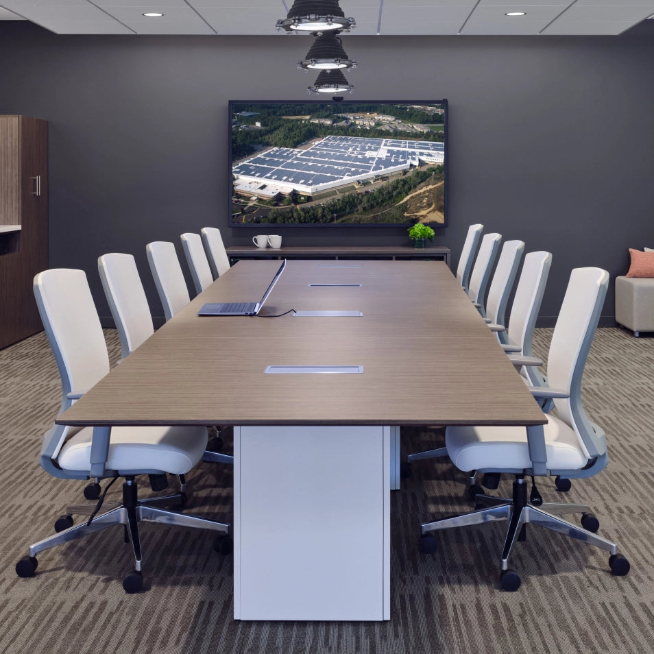 Conference room with a large table and chairs, featuring a screen displaying an outdoor scene. Kansas City Office Design.