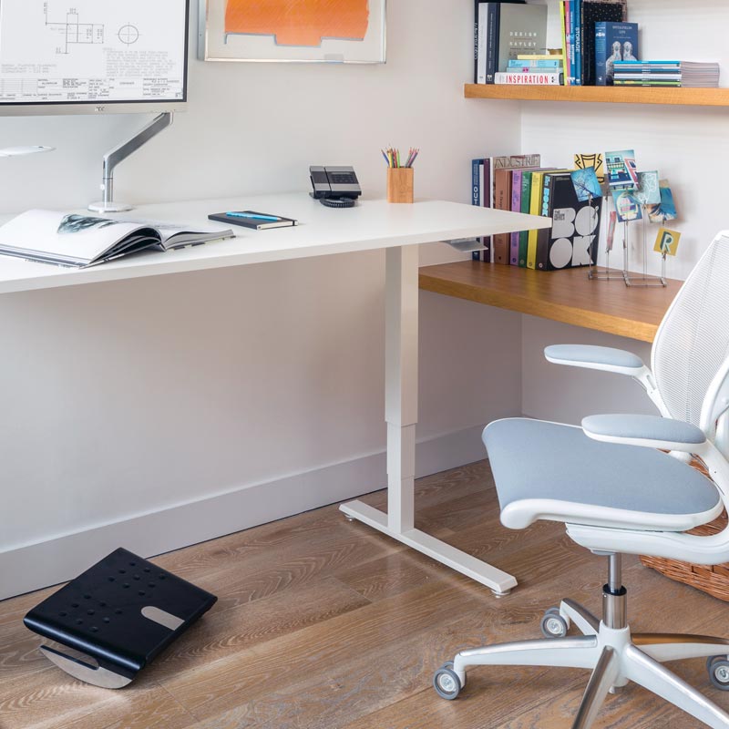 Home office setup with a adjustable desk, chair, and Humanscale FR500 black footrest. Kansas City Office Design. 