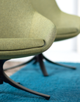 Green chair with black legs on a blue rug. Kansas City Office Design.