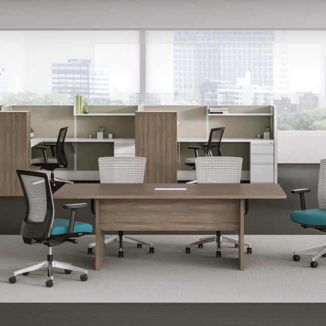 Modern office setup with desks, chairs, and partitions in a bright room. Kansas City Office Design.