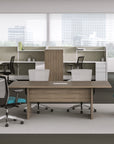 Modern office setup with desks, chairs, and partitions in a bright room. Kansas City Office Design.