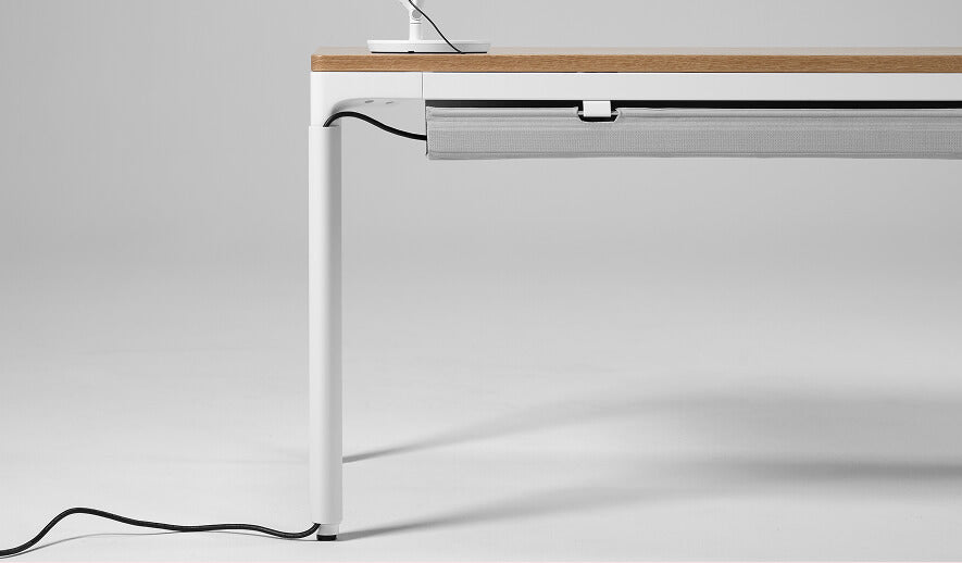 Modern Humanscale eFloat Quattro desk with a white frame and wooden top on a plain background. Kansas City Office Design.