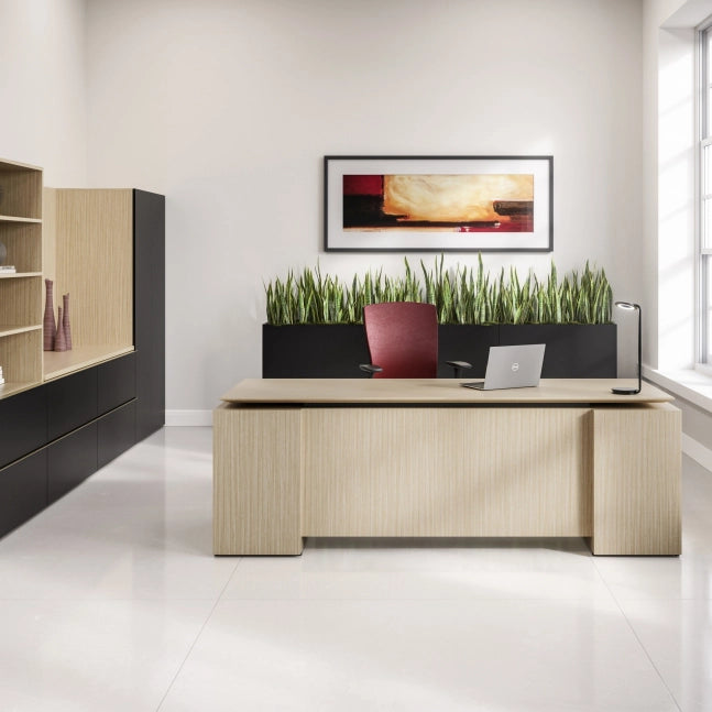 Modern office desk with a laptop and chair, featuring a decorative plant wall. Kansas City Office Design.
