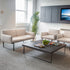 Modern living room with SitonIt Cameo beige sofas, club chairs, a coffee table, and decorative elements. Kansas City Office Design.