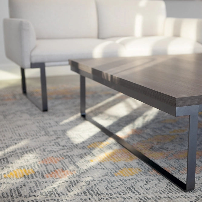 Wooden SitOnIt Cameo coffee table in a living room setting with a Cameo sofa and patterned rug. Kansas City Office Design