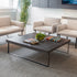 Modern living room with beige armchairs, a dark SitOnIt Cameo Square coffee table, and decorative items. Kansas City Office Design.