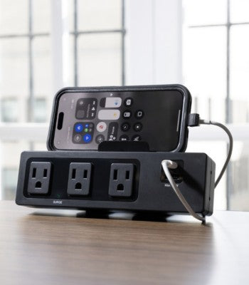 SitonIt Current Power strip with multiple outlets and a smartphone on a wooden surface. Kansas City Office Design.